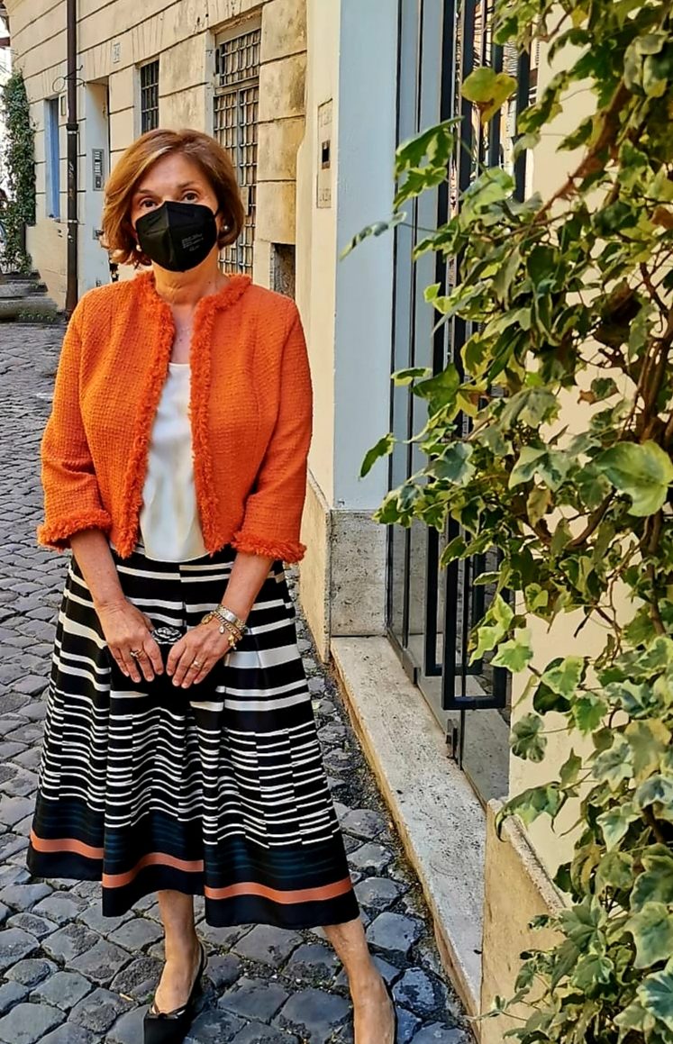 Marilena indossa una giacca chanel arancione e una blusa bianca fatta su misura da Chiara Cascioli